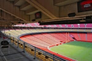 Innenansicht des GEHA Field at Arrowhead Stadium in Kansas City – Austragungsort der FIFA Fußball-Weltmeisterschaft 2026. Der Blick von der Tribüne zeigt die charakteristischen rot-gelben Sitzreihen des Stadions, Heimspielstätte der Kansas City Chiefs. Im Hintergrund ist eine Werbetafel für die WM 2026 zu erkennen. (Copyright Depositphotos.com)