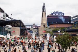 Fans strömen zum Gillette Stadium in Foxborough bei Boston – die markante Arena mit ihrem charakteristischen Leuchtturmturm ist einer der Austragungsorte der FIFA Fußball-Weltmeisterschaft 2026 in den USA und bietet rund 65.000 Zuschauern Platz. (Copyright Depositphotos.com)