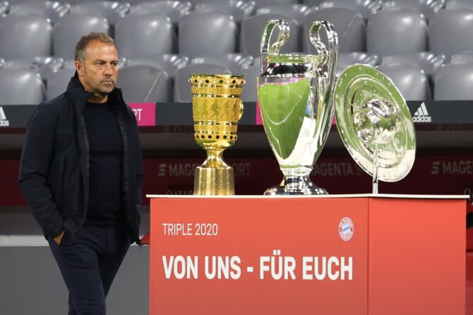 Hansi Flick, Cheftrainer des FC Bayern München, schreitet am 18. September 2020 in der Allianz Arena an den Pokalen für das historische Triple aus DFB-Pokal, Champions League und Meisterschaft vorbei – kurz vor dem Bundesliga-Auftaktspiel gegen den FC Schalke 04. (Alexander Hassenstein / Bongarts via Getty Images)