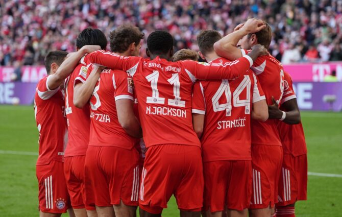 Harry Kane vom FC Bayern München bejubelt sein Tor zum 4:0 gegen den VfB Stuttgart am 19. April 2026 in der Allianz Arena – der englische Torjäger wird von seinen Mitspielern, darunter Nicolas Jackson (#11) und Josip Stanišić (#44), freudig umringt. Leonhard Simon / Getty Images