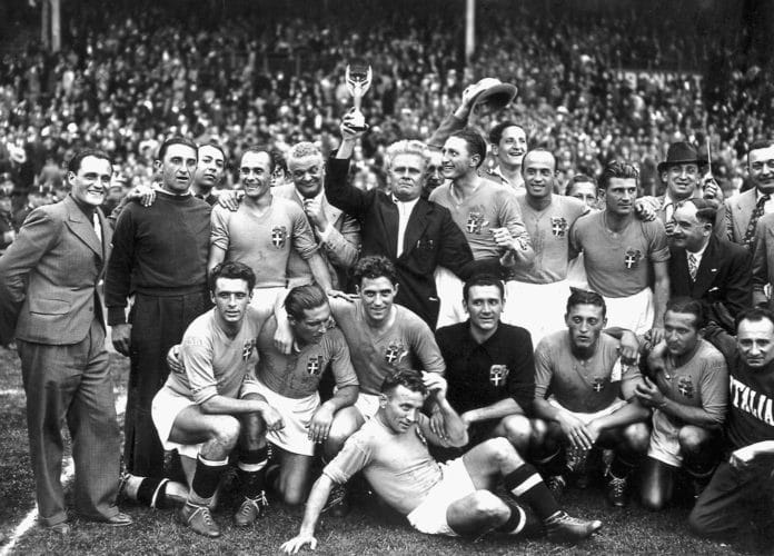 Italiens Nationalmannschaft gewinnt nach einem 4:2 Sieg gegen Ungarn die Fußball-Weltmeisterschaft 1938. (vorne von links : Amadeo Biavati (4th L), coach Vittorio Pozzo holding the trophy, Silvio Piola, Giovanni Ferrari, Gino Colaussi; erste Reihe von links : Ugo Locatelli, Giuseppe Meazza, Alfredo Foni, Pietro Serantoni, Aldo Olivieri, Pietro Rava and Michele Andreolo) / AFP PHOTO / STAFF