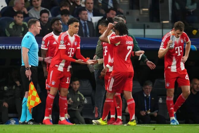 Jamal Musiala vom FC Bayern München spricht bei seiner Einwechslung mit Teamkollege Serge Gnabry beim Hinspiel des UEFA Champions League Viertelfinals 2025/26 zwischen Real Madrid CF und dem FC Bayern München am 7. April 2026 im Estadio Santiago Bernabéu in Madrid. Aitor Alcalde / Getty Images Europe via Getty Images