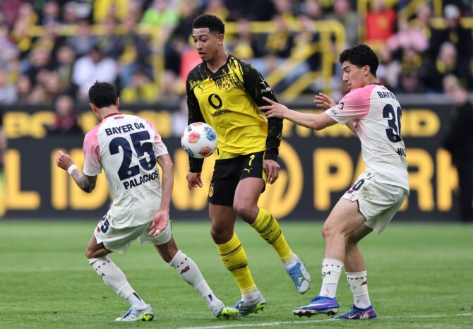 Jobe Bellingham von Borussia Dortmund behauptet sich im Zweikampf gegen Exequiel Palacios (Nr. 25) und Ibrahim Maza von Bayer 04 Leverkusen beim Bundesliga-Spiel im Signal Iduna Park in Dortmund am 11. April 2026. Foto: Christof Koepsel / Getty Images Europe via Getty Images