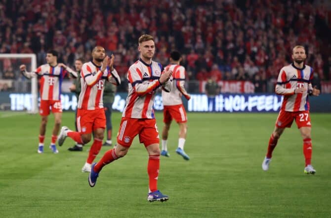 Joshua Kimmich applaudiert den Fans in der ausverkauften Football Arena München beim Aufwärmen vor dem UEFA Champions League Viertelfinale-Rückspiel gegen Real Madrid CF am 15. April 2026. Im Hintergrund feiern weitere FC-Bayern-Spieler die Stimmung auf den Rängen. Alex Grimm / Getty Images