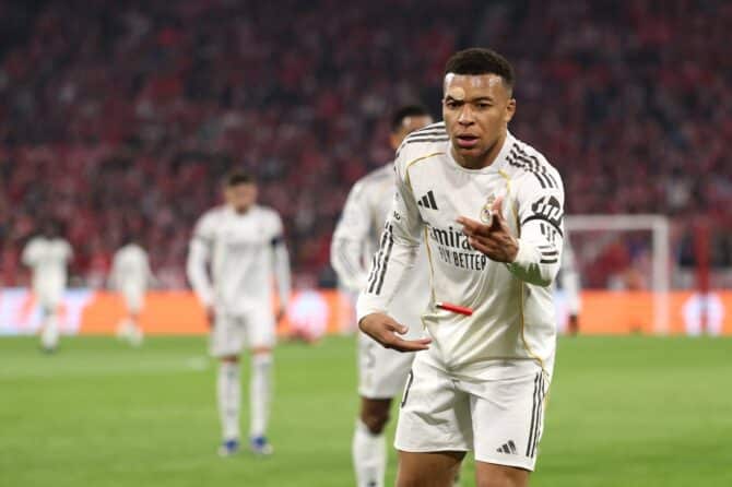 Kylian Mbappé hebt nach dem Jubel zum 3:0 ein auf den Rasen geworfenes Feuerzeug auf im UEFA Champions League Viertelfinale-Rückspiel zwischen dem FC Bayern München und Real Madrid CF am 15. April 2026 in München. Adam Pretty / Getty Images
