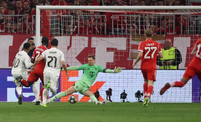 Kylian Mbappé schießt das 3:0 für Real Madrid an Manuel Neuer vorbei im UEFA Champions League Viertelfinale-Rückspiel gegen den FC Bayern München am 15. April 2026 in der Football Arena München. Im Hintergrund ist Konrad Laimer zu sehen. Lars Baron / Getty Images
