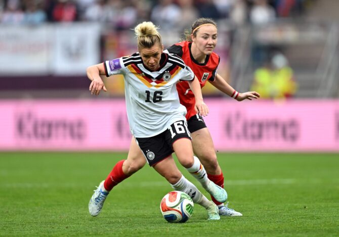 Lina Magull (Nr. 16) von der deutschen Frauen-Nationalmannschaft dribbelt im WM-Qualifikationsspiel gegen Österreich und setzt sich gegen Marie Brunnthaler durch. Die Mittelfeldspielerin des FC Bayern München war eine der Schlüsselspielerinnen beim Spiel am 14. April 2026 im Max-Morlock-Stadion in Nürnberg. Christian Kaspar-Bartke / Getty Images