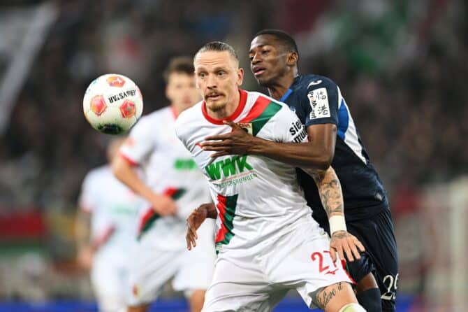 Marius Wolf vom FC Augsburg behauptet den Ball im Zweikampf gegen Bazoumana Touré von der TSG 1899 Hoffenheim in der WWK-Arena. Die Begegnung fand am 10. April 2026 in Augsburg im Rahmen der Bundesliga statt. Christian Kaspar-Bartke / Getty Images