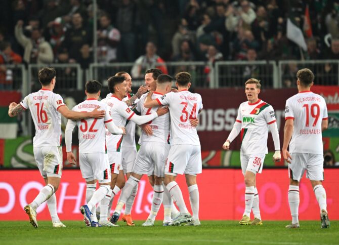 Michael Gregoritsch vom FC Augsburg bejubelt sein Tor zum 2:0 gegen die TSG 1899 Hoffenheim mit seinen Mitspielern in der WWK-Arena. Der Stürmer war beim Bundesliga-Heimspiel am 10. April 2026 in Augsburg maßgeblich am Sieg beteiligt. Christian Kaspar-Bartke / Getty Images