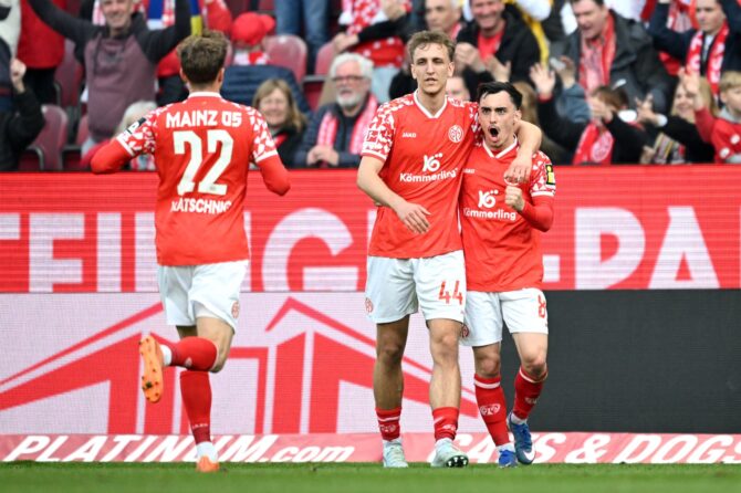 Paul Nebel, Nelson Weiper und Nikolas Veratschnig von Mainz 05 bejubeln den Sieg nach dem Bundesligaspiel gegen Eintracht Frankfurt in der MEWA Arena am 22. März 2026 in Mainz. Foto: Christian Kaspar-Bartke / Getty Images