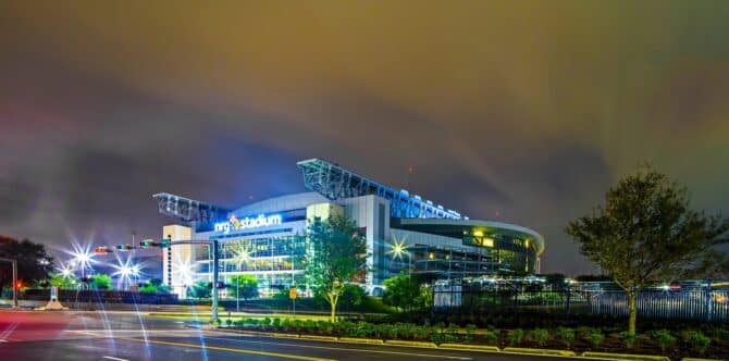Das NRG Stadium in Houston erstrahlt bei Nacht in leuchtendem Blau – die Heimstätte der Houston Texans ist einer der Austragungsorte der FIFA Fußball-Weltmeisterschaft 2026 in den USA und bietet mit seinem einzigartigen Retractable-Roof-Design rund 72.000 Zuschauern Platz. (Copyright Depositphotos.com)