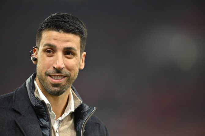 Sami Khedira lächelt vor Anpfiff des Bundesligaspiels zwischen dem VfB Stuttgart und RB Leipzig am 15. März 2026 in der MHPArena in Stuttgart. Der Weltmeister von 2014 war als TV-Experte vor Ort – erkennbar am Ohrhörer. (Sebastian Widmann / Getty Images)