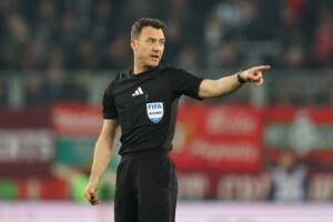Mit entschlossenem Fingerzeig gibt der FIFA-Referee seine Entscheidung durch: Ein Schiedsrichter leitet die Bundesligapartie zwischen dem FC Augsburg und dem VfB Stuttgart am 22. März 2026 in der WWK Arena in Augsburg. Getty Images