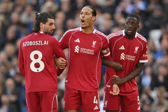 Liverpools Kapitän Virgil van Dijk reagiert lautstark auf eine Schiedsrichterentscheidung, während ihn seine Teamkollegen Dominik Szoboszlai (links, Nr. 8) und Ibrahima Konaté (rechts, Nr. 5) flankieren – aufgenommen am 21. März 2026 beim Premier-League-Gastspiel des FC Liverpool bei Brighton & Hove Albion. Mike Hewitt / Getty Images