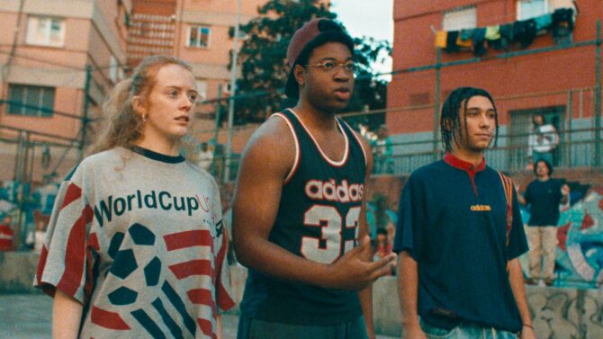 Drei junge Darsteller in Retro-Sportkleidung der 90er-Jahre stehen in einem Hinterhof – darunter ein Original-Trikot der WM USA 1994 und klassische adidas-Jerseys. Eine Szene aus dem adidas-Kurzfilm "Backyard Legends", der die Entstehung von Legenden vom Hinterhof bis zur Weltmeisterschaftsbühne 2026 erzählt. (Copyright adidas)