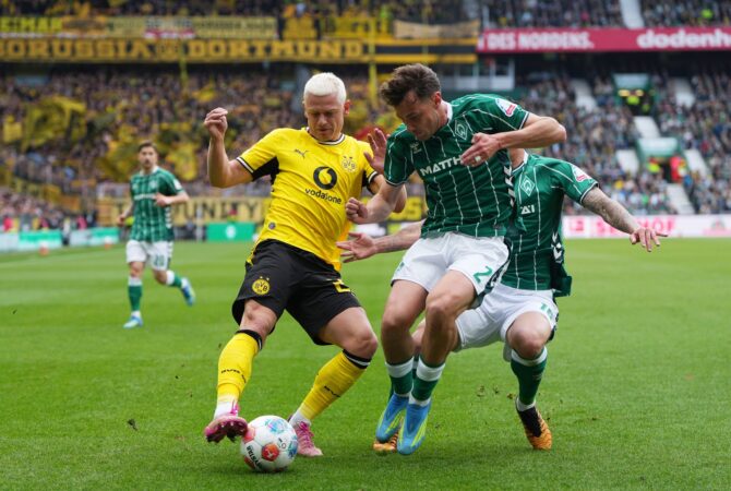 Julian Ryerson von Borussia Dortmund behauptet den Ball gegen Olivier Deman und Cameron Puertas vom SV Werder Bremen. Die Szene entstand beim Bundesliga-Spiel zwischen dem SV Werder Bremen und Borussia Dortmund im Weserstadion in Bremen, Mai 2026. Pau Barrena / Getty Images