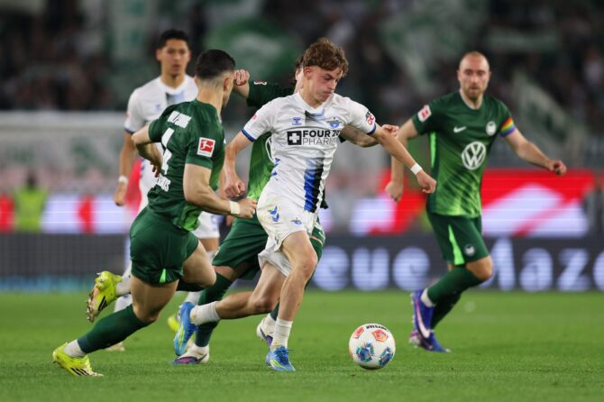 Ruben Müller vom SC Paderborn 07 zieht im Bundesliga-Relegations-Hinspiel beim VfL Wolfsburg am 21. Mai 2026 in der Volkswagen Arena unter Druck von Konstantinos Koulierakis mit dem Ball davon. (Selim Sudheimer / Getty Images Europe via Getty Images)