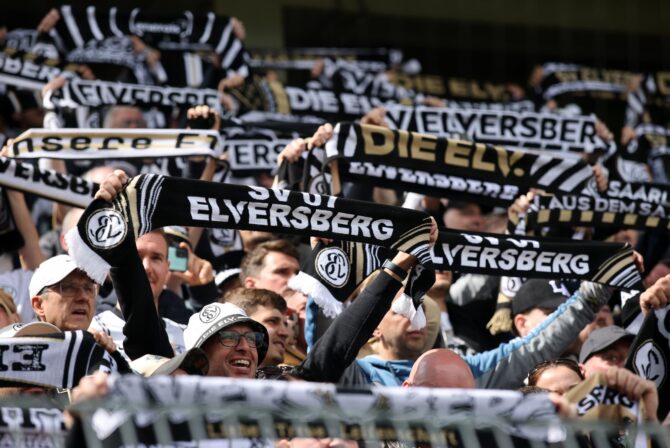 Die Anhänger des SV 07 Elversberg recken vor dem Anpfiff ihre Vereinsschals in die Höhe und stimmen sich in der Ursapharm-Arena auf das Zweitliga-Heimspiel gegen den SC Preußen Münster am 17. Mai 2026 ein. Alex Grimm / Getty Images