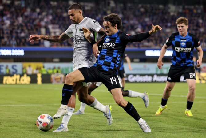 Vinicius Souza vom VfL Wolfsburg im Zweikampf mit Mika Joel Baur (Nr. 14) vom SC Paderborn im Bundesliga-Relegationsrückspiel in der Home Deluxe Arena am 25. Mai 2026 in Paderborn. Wolfsburg sicherte sich in diesem Spiel den Klassenerhalt. Christof Koepsel / Getty Images Europe via Getty Images