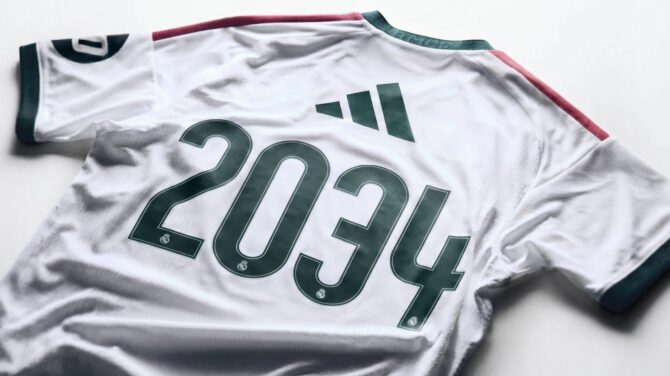 Weißes adidas-Trikot mit dunkelgrüner Rückennummer 2034 und roten Akzenten.
