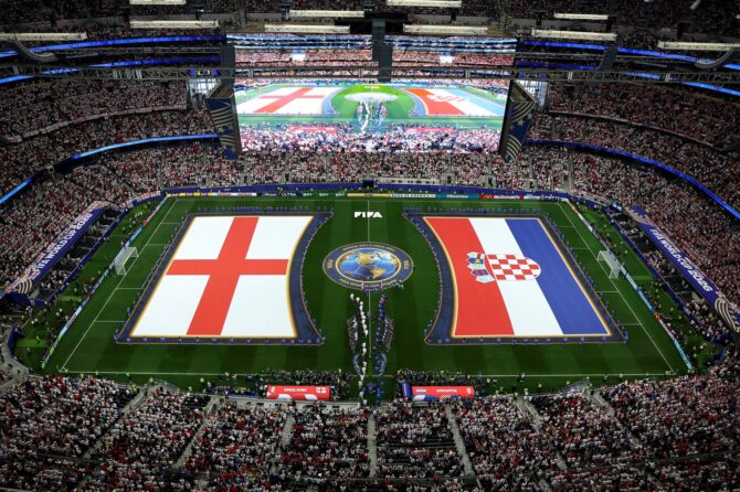 Weitwinkelaufnahme des voll besetzten Dallas Stadium mit den auf dem Rasen ausgebreiteten Flaggen Englands und Kroatiens, während sich die Mannschaften vor dem Gruppenspiel L der FIFA Weltmeisterschaft 2026 am 17. Juni 2026 in Arlington, Texas, aufstellen. Stacy Revere / Getty Images
