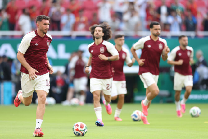 Spaniens Aymeric Laporte beim Aufwärmen vor dem Anpfiff, im Hintergrund weitere Spieler in roten Trikots