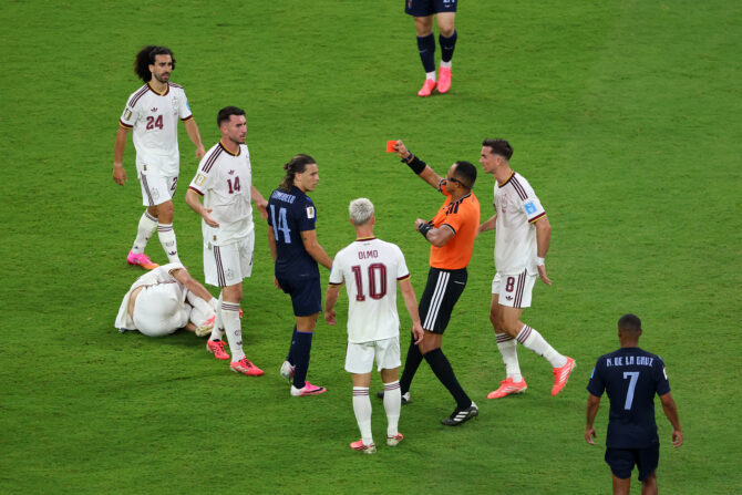 Schiedsrichter Ismail Elfath zeigt Uruguays Agustín Canobbio die Rote Karte, umringt von spanischen Spielern.
