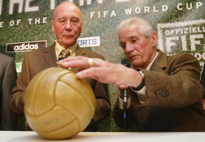 KAISERSLAUTERN, GERMANY - NOVEMBER 05: Fussball: Weltmeisterschaft 2006, Kaiserslautern; Eroeffnung des offiziellen FIFA WM 2006-Shops.; Horst ECKEL (l.) und Ottmar WALTER (r.) begutachten den original WM-Ball von 1954 05.11.04. (Photo by Alexander Heimann/Bongarts/Getty Images)