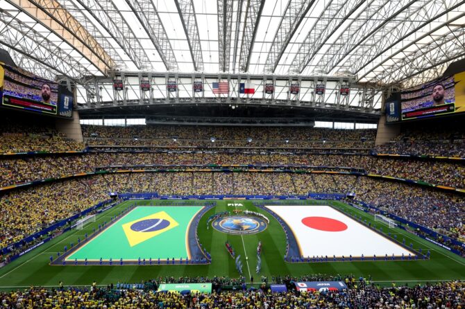 Riesige Nationalflaggen von Brasilien und Japan bedecken den Rasen, während sich beide Mannschaften vor dem Anpfiff im ausverkauften Houston Stadium aufstellen. Die Aufnahme entstand vor dem Sechzehntelfinale der WM 2026 zwischen Brasilien und Japan am 29. Juni 2026. (Molly Darlington / Getty Images)