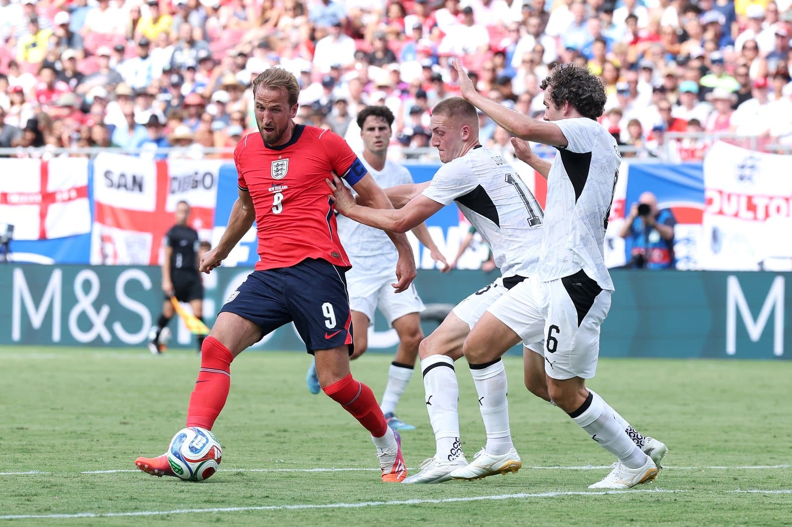 Englands Kapitaen Harry Kane (Nr. 9) behauptet im Test-Laenderspiel gegen Neuseeland den Ball gegen Finn Surman und Joe Bell. Die Partie fand am 6. Juni 2026 im Raymond James Stadium von Tampa statt. Richard Pelham / Getty Images