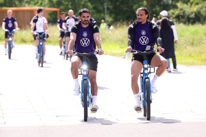 Ilkay Gündogan (l.) und Leroy Sané kommen mit dem Fahrrad zum Training der deutschen Nationalmannschaft am 10. Juni 2024 auf dem Adi-Dassler-Sportplatz in Herzogenaurach während der EM 2024. (Alexander Hassenstein / Getty Images)