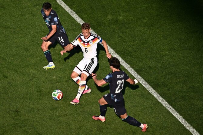 Der deutsche Kapitän Joshua Kimmich (Nummer 6) schirmt den Ball gegen die beiden Paraguayer Andres Cubas (Nummer 14) und Matias Galarza (Nummer 23) ab. Aufgenommen im Sechzehntelfinale der WM 2026 zwischen Deutschland und Paraguay im Boston Stadium in Foxborough am 29. Juni 2026. (Copyright AFP/Jewel Samad)
