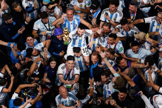 LUSAIL CITY, KATAR - 18. Dezember: Lionel Messi aus Argentinien feiert nach dem Sieg im Finale der FIFA-Weltmeisterschaft Katar 2022 gegen Frankreich mit der Sieger-Trophäe auf den Schultern von Sergio „Kun“ Agüero im Lusail Stadium am 18. Dezember 2022 in Lusail City, Katar. (Foto: Matthias Hangst/Getty Images)