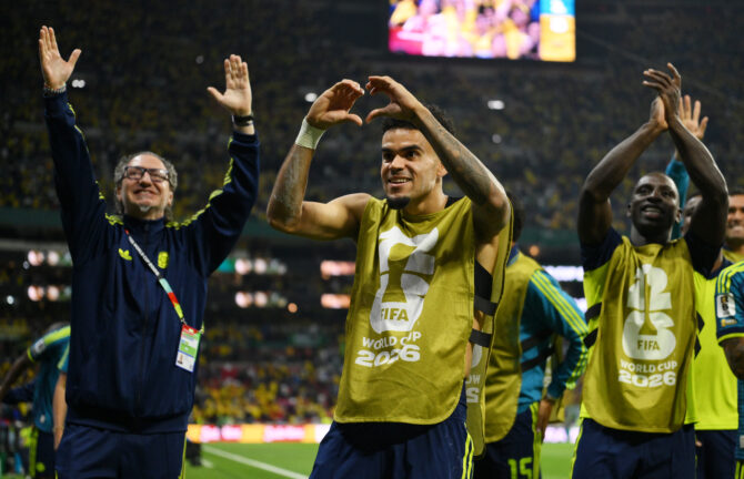 Luis Díaz formt mit den Händen ein Herz, neben ihm applaudieren kolumbianische Spieler den Fans im Stadion.