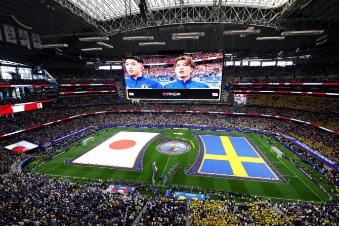 Die Mannschaften und Offiziellen stehen vor dem WM-Gruppenspiel der Gruppe F zwischen Japan und Schweden zur Nationalhymne, auf dem Rasen des Dallas Stadium in Arlington sind die Flaggen beider Nationen zu sehen. Die Partie fand am 25. Juni 2026 statt. Lars Baron / Getty Images