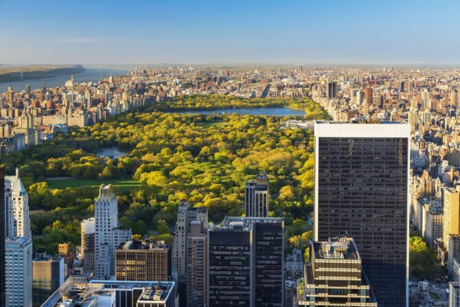 Luftaufnahme des New Yorker Central Park, der sich als weitläufige grüne Oase zwischen den Hochhäusern Manhattans erstreckt. Im Hintergrund schimmert der Hudson River. New York gehört zu den Austragungsorten der Fußball-Weltmeisterschaft 2026. (Copyright Depositphotos.com)