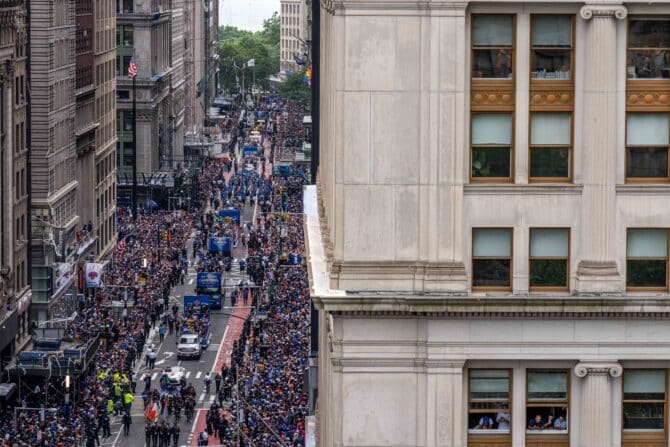New York, New York, USA, 18. Juni 2026: Menschen verfolgen aus den Fenstern die Ticker-Tape-Parade der New York Knicks zur Feier des NBA-Titels 2026 in New York City. Die Knicks gewannen die NBA Finals gegen die San Antonio Spurs in fünf Spielen und sicherten sich ihre erste Meisterschaft seit 53 Jahren. (Foto: Adam Gray/Getty Images)