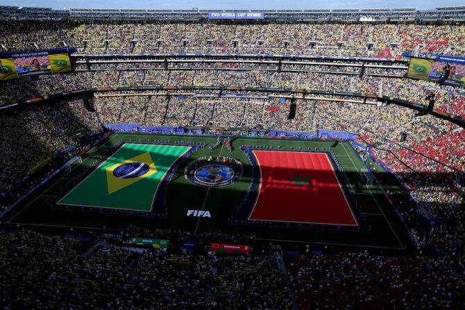 Blick von oben auf das ausverkaufte New York New Jersey Stadium, auf dessen Rasen die übergroßen Flaggen Brasiliens und Marokkos ausgebreitet sind, während sich die Mannschaften vor dem WM-2026-Gruppenspiel der Gruppe C in East Rutherford, New Jersey, am 13. Juni 2026 aufstellen. Al Bello / Getty Images