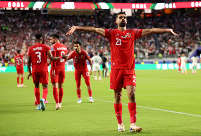 Jordaniens Nizar Al Rashdan jubelt mit weit ausgebreiteten Armen nach seinem Tor, dahinter Mitspieler