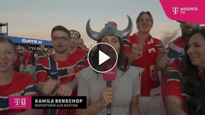 MagentaTV-Reporterin Kamila Benschop mit Wikinger-Helm zwischen euphorischen Norwegen-Fans beim WM-2026-Spiel Irak gegen Norwegen.