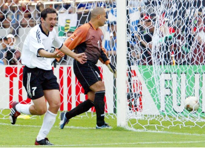 Oliver Neuville jubelt über seinen Siegtreffer zum 1:0 für Deutschland im WM-Achtelfinale gegen Paraguay am 15. Juni 2002 in Seogwipo, Südkorea. Im Hintergrund steht Paraguays Torhüter José Luis Chilavert. (Foto: Sandra Behne/Bongarts/Getty Images)