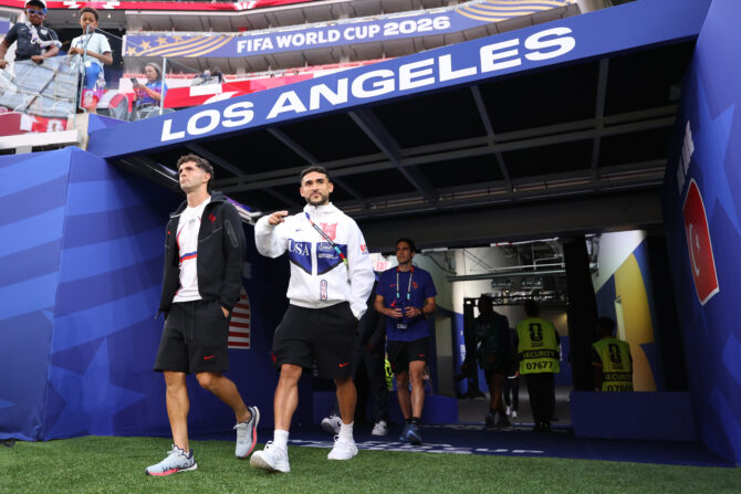 Zwei US-Nationalspieler in Freizeitkleidung gehen durch den Stadiontunnel mit der Aufschrift Los Angeles aufs Spielfeld.