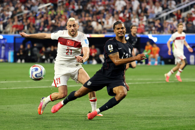 Ein US-Verteidiger im dunklen Trikot und ein türkischer Angreifer in Weiß laufen um den Ball.