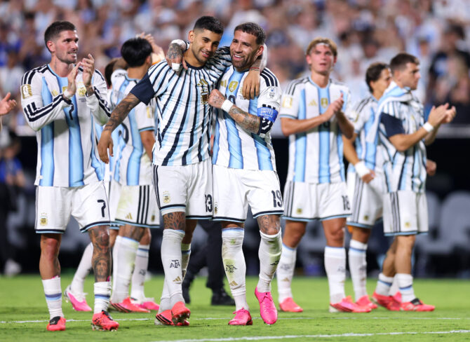 Argentiniens Verteidiger Cristian Romero und Nicolás Otamendi feiern Arm in Arm auf dem Rasen
