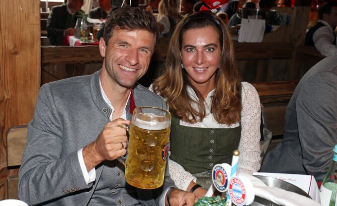 Thomas Müller, Offensivspieler des FC Bayern München, besucht gemeinsam mit seiner Frau Lisa das Oktoberfest. Die beiden sitzen am 18. September 2022 in der Käfer Wiesnschänke auf der Theresienwiese in München, Müller in Tracht und mit einer Maß Bier in der Hand. Stefan Matzke - Pool / Getty Images