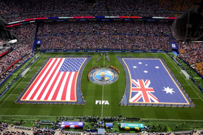 Spieler und Schiedsrichter stellen sich vor dem WM-2026-Gruppenspiel zwischen den USA und Australien am 19. Juni 2026 im Seattle Stadium auf, auf dem Rasen sind die Riesenflaggen beider Nationen ausgebreitet. (Alex Grimm / Getty Images)
