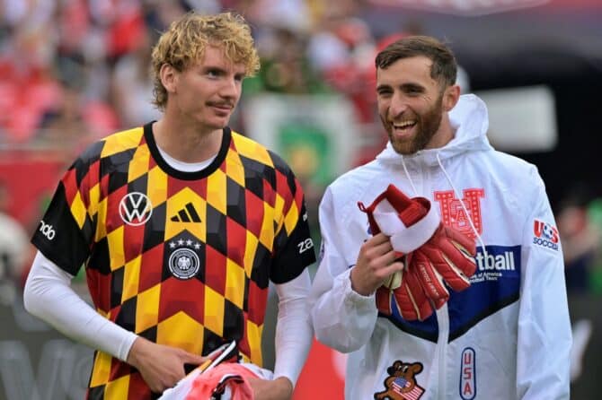 Nick Woltemade im deutschen Adidas-Prematch-Trikot tauscht beim Aufwärmen vor dem Testspiel Deutschland gegen USA am 6. Juni 2026 in Chicago einen heiteren Moment mit einem US-Nationalspieler aus. Der Stürmer gehört zum DFB-Kader für die WM 2026. (Copyright AFP/Jacek Boczarski)