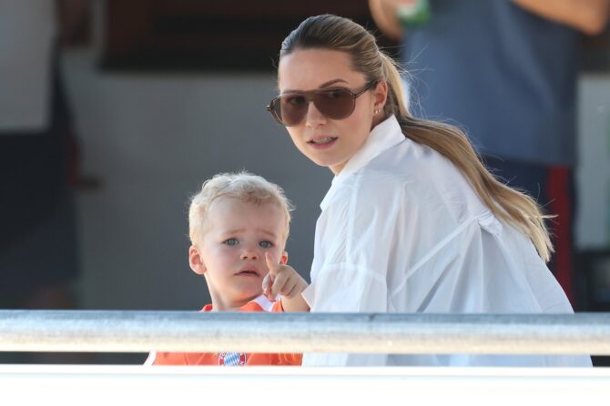 Luca Neuer verfolgt am 28. Juli 2026 gemeinsam mit seiner Mutter Anika Neuer, der Ehefrau von Bayern-Torhüter Manuel Neuer, eine Trainingseinheit des FC Bayern München im Stadion am Birkenmoos in Rottach-Egern. (Alexander Hassenstein / Getty Images Europe via Getty Images)