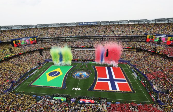 Riesige Flaggen von Brasilien und Norwegen sowie Feuerwerk prägen die Zeremonie vor dem Anpfiff des Achtelfinals der WM 2026 zwischen beiden Teams am 5. Juli 2026 im New York New Jersey Stadium in East Rutherford, während sich die Mannschaften und Schiedsrichter in der Mitte aufstellen. (Dan Mullan / Getty Images North America via Getty Images)
