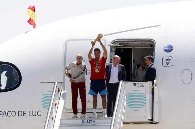 Kapitän Rodri stemmt bei der Ankunft am Flughafen Adolfo Suárez Madrid-Barajas den WM-Pokal in die Höhe, an seiner Seite Nationaltrainer Luis de la Fuente und Verbandspräsident Rafael Louzán. Pablo Blazquez Dominguez / Getty Images